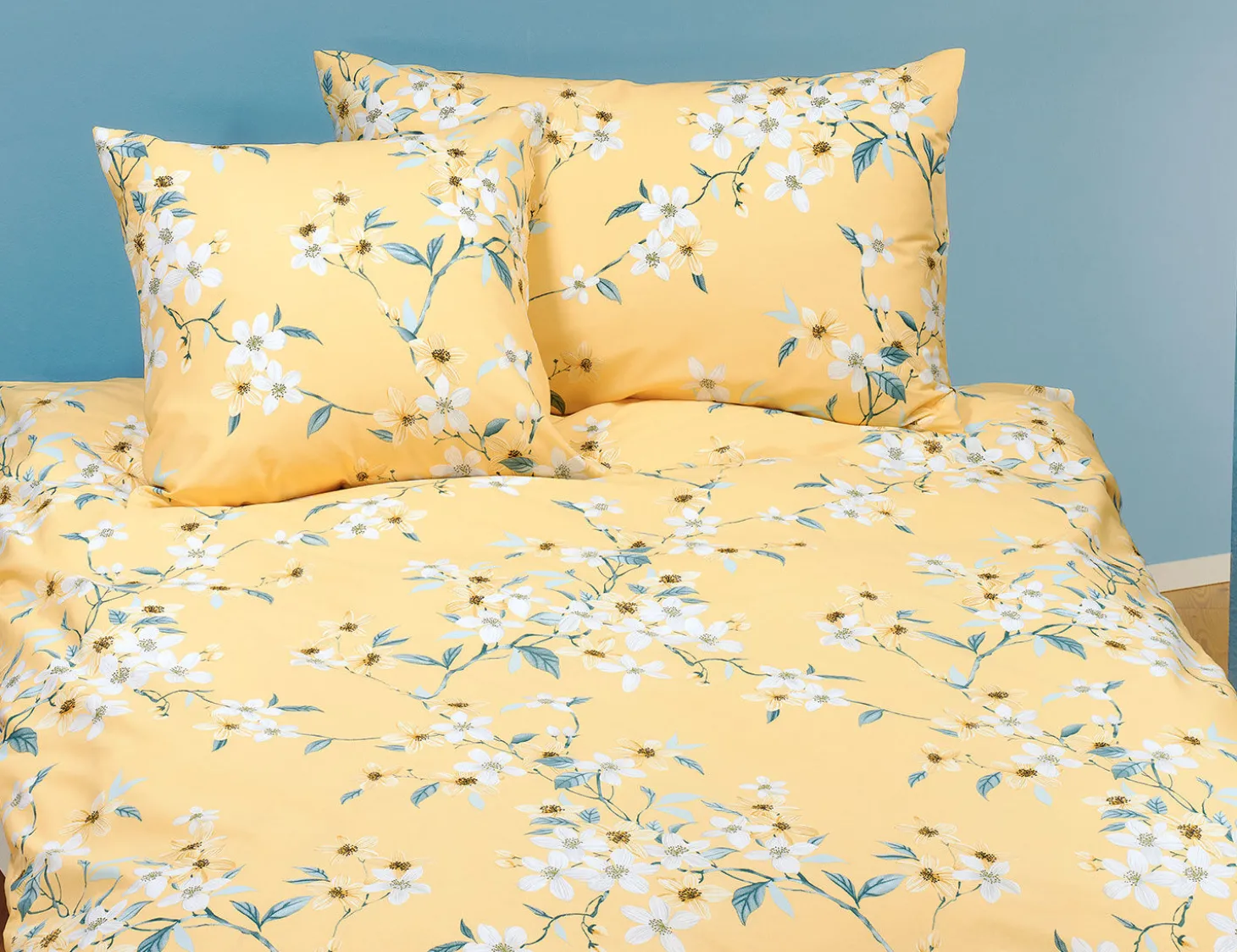Bettwäsche mit schönem Blumenmuster auf hellem Untergrund